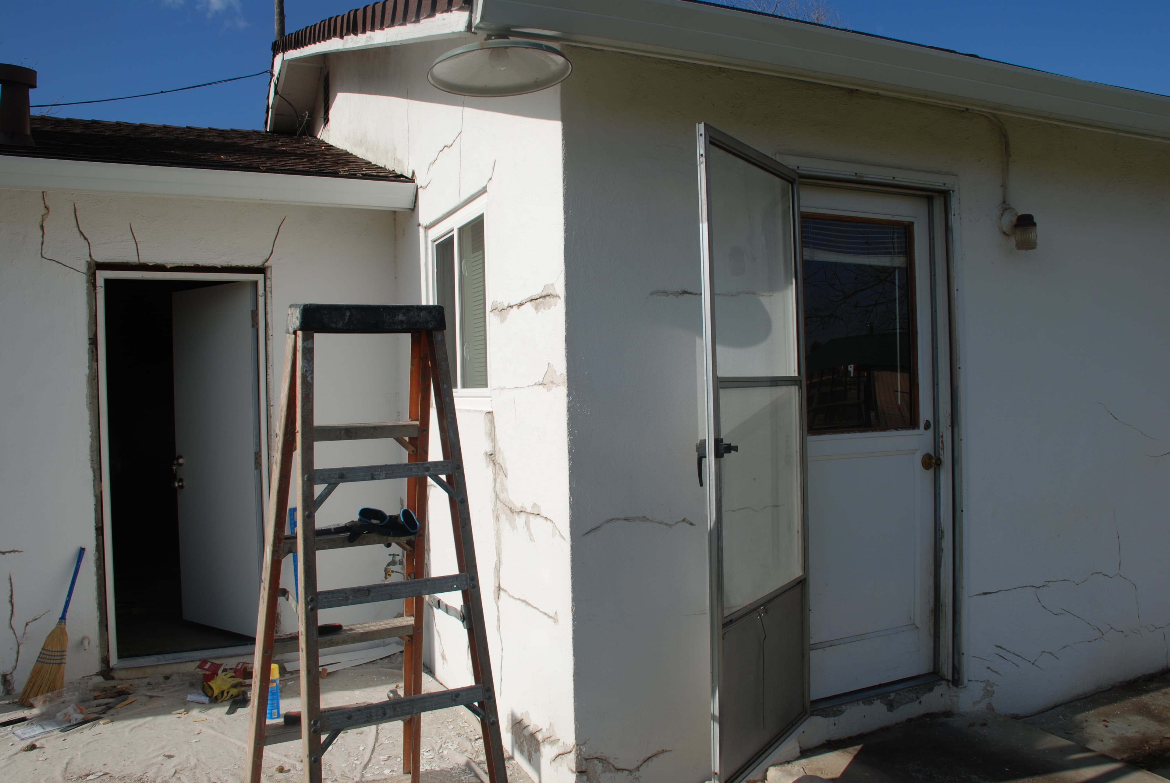 Stucco cracks visible around exterior door and window openings on a Sacramento-area home