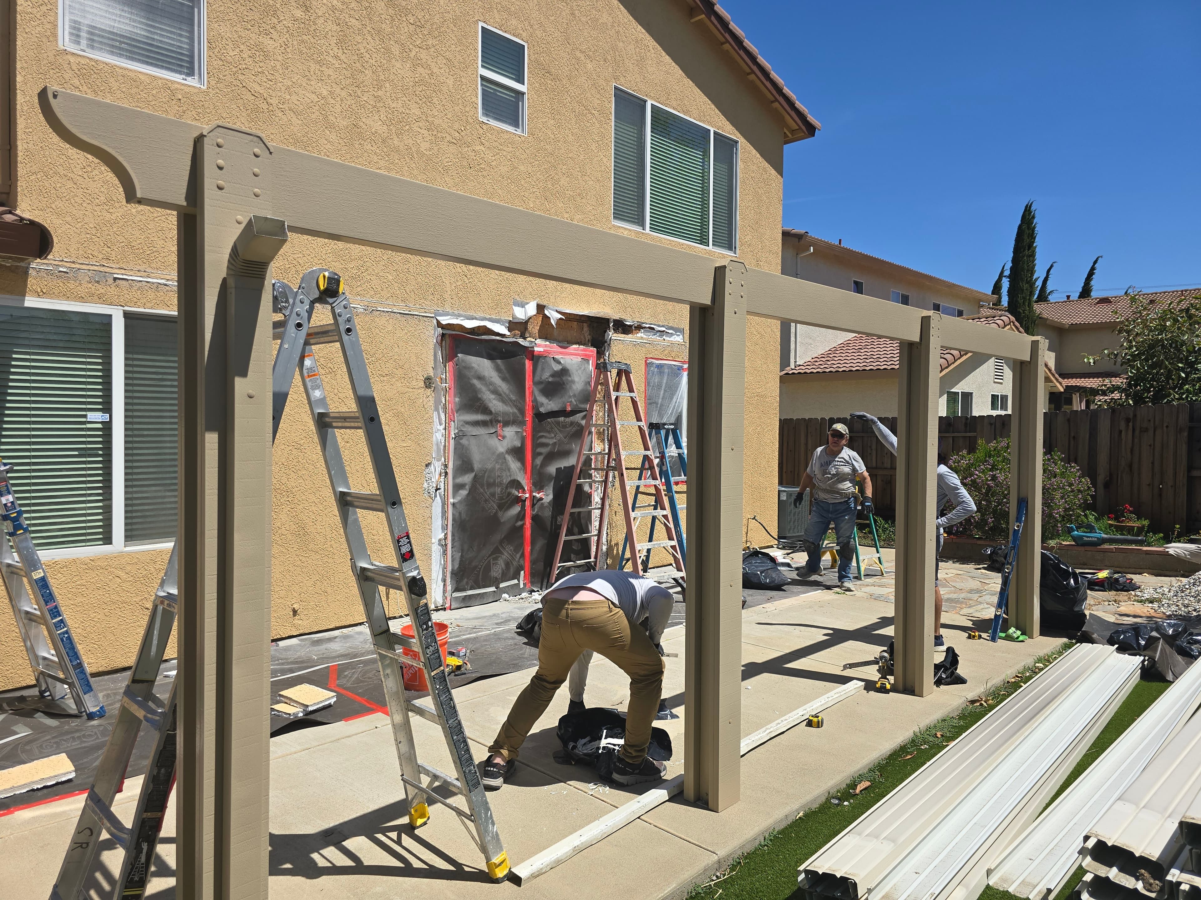 HomePRO crew repairing concealed water damage where a patio cover attaches to a stucco home
