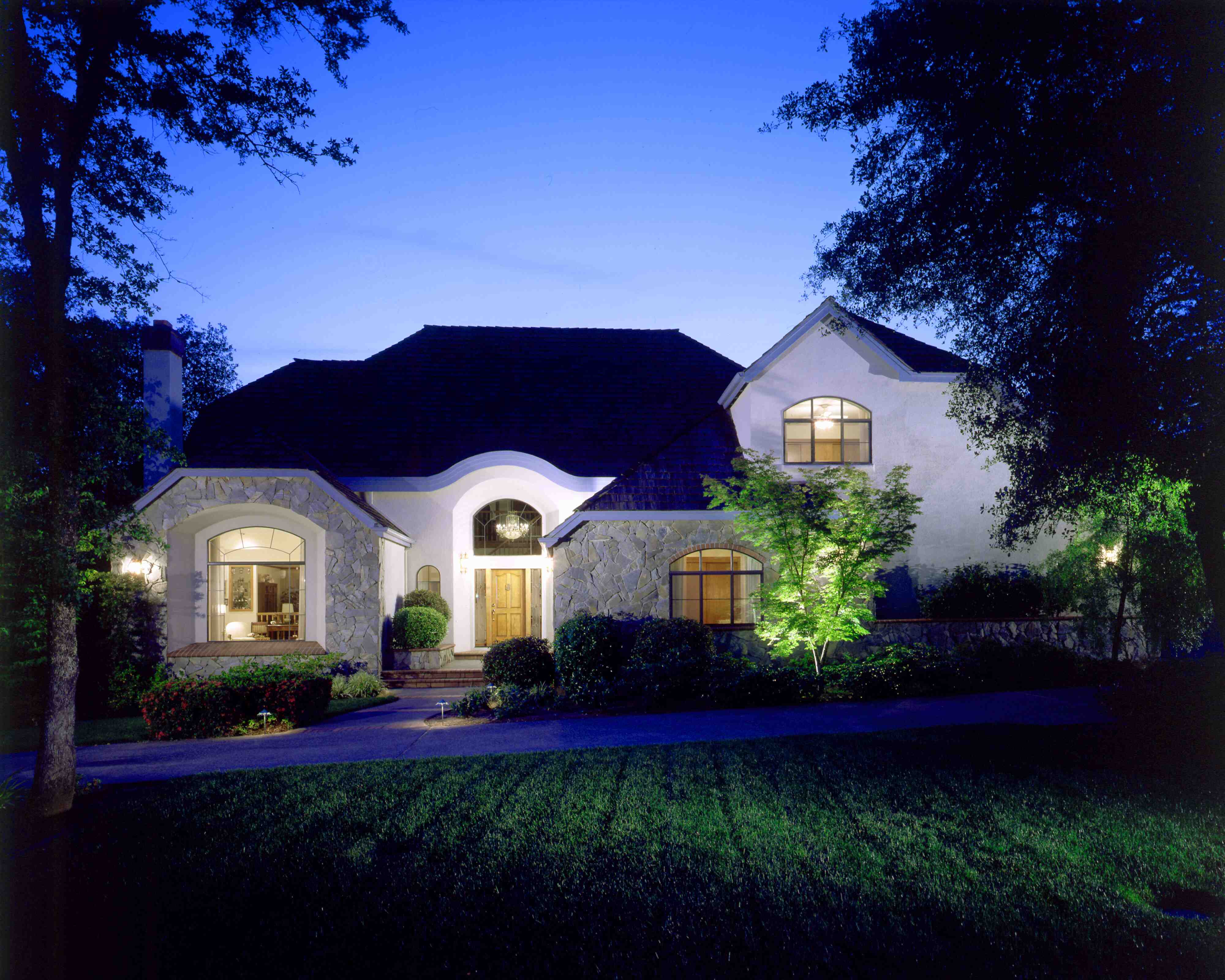 Stone and stucco custom home glowing at dusk after a HomePRO exterior restoration